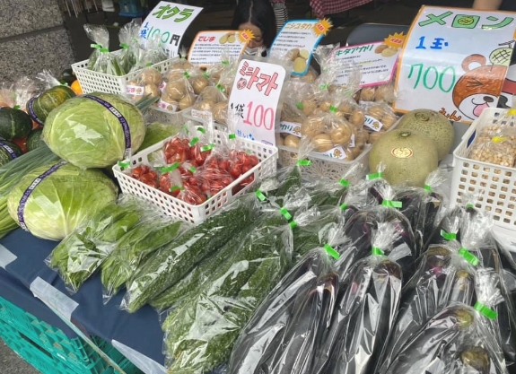 マルシェに野菜が並んでいます、ミニトマト、ゴーヤ、ナス、メロン、ジャガイモ、オクラ、キャベツ、カボチャなどあります。